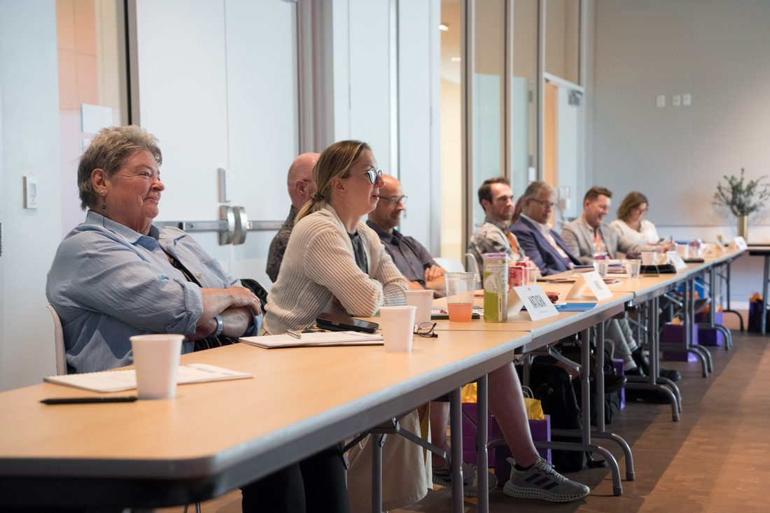 Participants seated around the Lab table in discussion