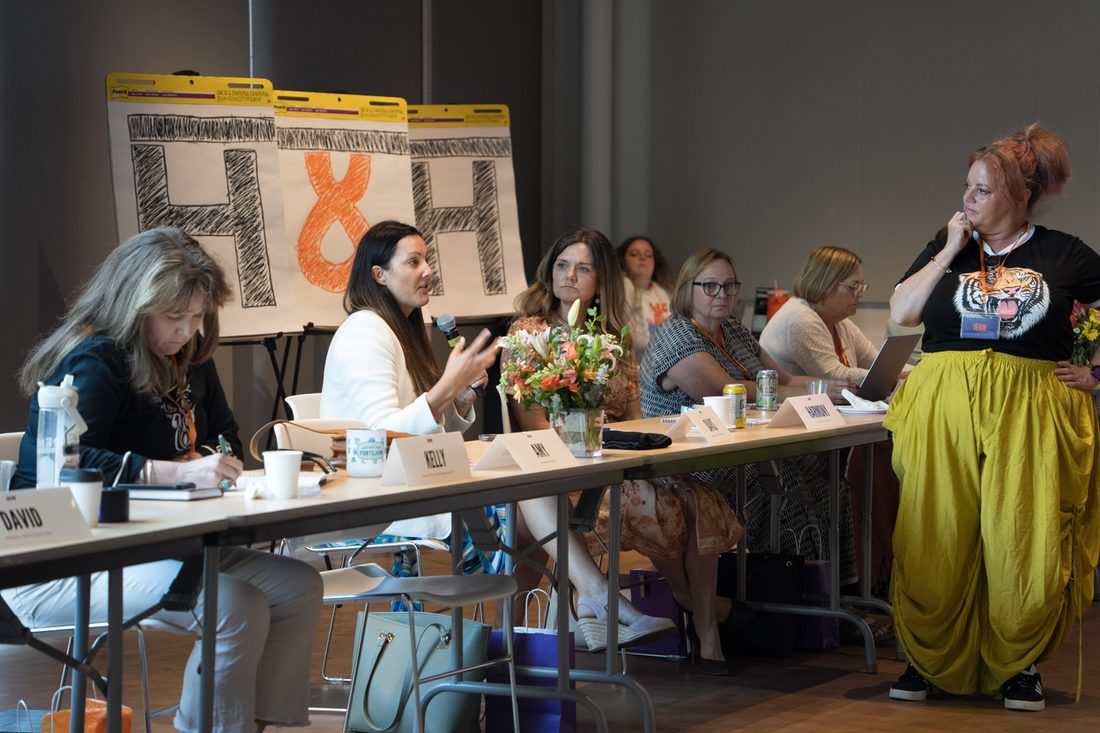 A participant presenting at a flip chart during a build round